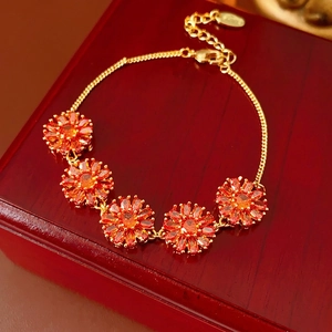 Luxury gold plated bracelet with five orange zircon sunflowers on wood jewelry box