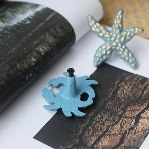 Blue ocean themed cabinet pulls featuring starfish and crab shapes in rustic cast iron