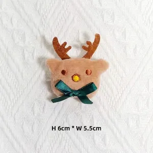 Détail de tête de renne en peluche avec broderie et nœud, taille 6 cm par 5,5 cm