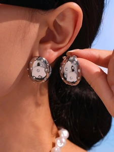 Detailed view of silver oval earrings with sparkling cubic zirconia on a model