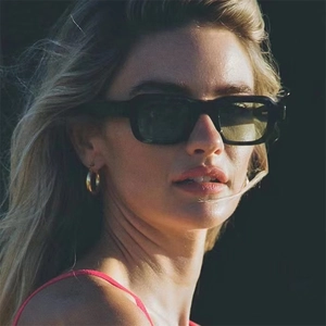 Classic square sunglasses with thick matte black frames and dark lenses on a female model