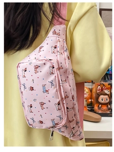 Pink cartoon dachshund sling bag with adjustable strap shown worn on model's back