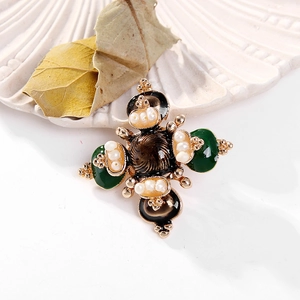 Baroque style cross brooch with freshwater pearls and green enamel on a white shell plate