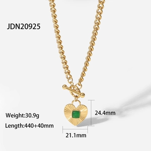Detail view of gold Cuban chain necklace with green agate heart pendant and OT toggle clasp