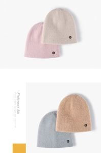 Detailed knit texture of four beanies in pink, beige, blue, and brown with letter R tag