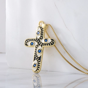 18K gold plated cross necklace featuring blue evil eye zircon charms on marble background