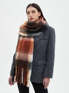 Close-up of a thick checkered scarf with orange and brown patterns and fringe details
