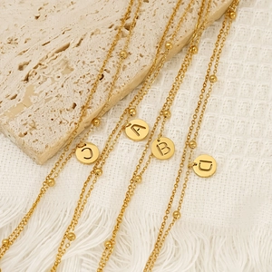 Collier en acier inoxydable plaqué or avec perles et pendentifs lettres ajourés