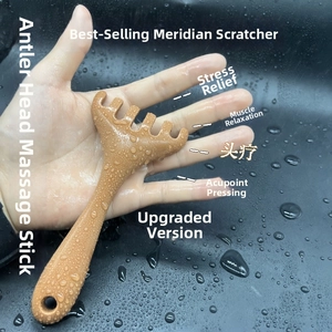 Detail of a brown five-tooth antler scalp massager being held for head and neck acupoint therapy