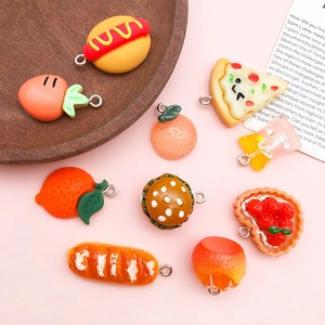Close-up of assorted resin food charms including burger and pizza on a wooden tray