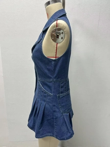Dettaglio di un abito di jeans blu scuro con orlo a pieghe e silhouette a trapezio