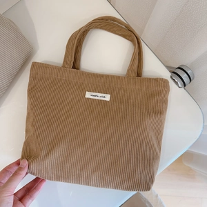 Detail view of corduroy tote bag with simple wish label and soft texture