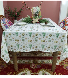 Detail of Christmas tablecloth featuring festive prints like trees and gingerbread men