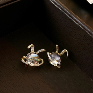 Detail of gold plated rabbit planet stud earring with sparkling resin and zircon accents