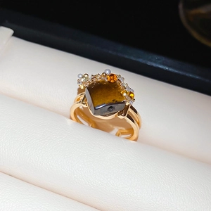 Macro shot of tiger eye stone ring with cubic zirconia on a beige leather display