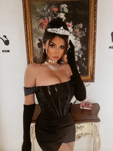 Détail d'une robe noire à paillettes avec gants longs et parure de bijoux de luxe