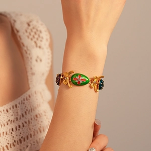 Detail of vintage gold bracelet with enamel butterfly and rhinestone insect charms