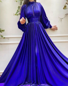 Close-up of metallic pleated fabric texture on elegant purple evening gown with long sleeves