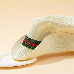 Detail of summer straw cowboy hat with distinctive red and green rhinestone stripe band