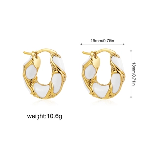 Detail view of 18K gold earrings with white enamel showing 19mm width and 18mm height