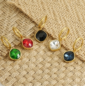 Detail showing five colors of zircon drop earrings on a rustic burlap background