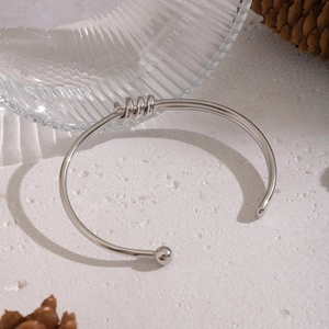Detail of twisted spiral design and smooth bead end on a silver stainless steel bangle