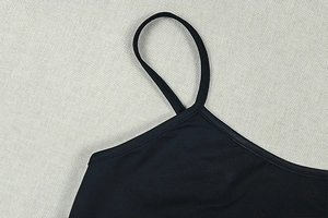 Detail of thin shoulder straps and neckline on black slim-fit knitted long dress