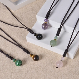 Detail of natural tiger eye and amethyst pendants with dark brown braided rope cords