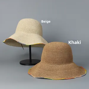 Detail view of handmade beige and khaki wide brim straw hats with wavy edges