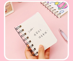 Close-up of portable A7 mini notebook with metal dual-coil binding and white pages