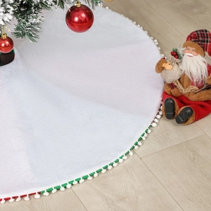 White plush Christmas tree skirt with festive red green and white pom pom trim decor