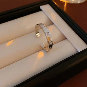 Détail d'une bague ouverte gravée étoile avec zircon dans un écrin cadeau