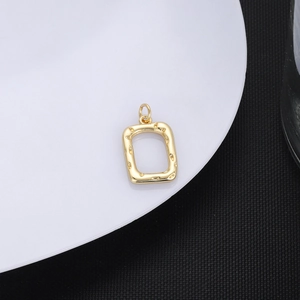 Macro shot of 18K gold plated rectangular pendant with unique hammered texture