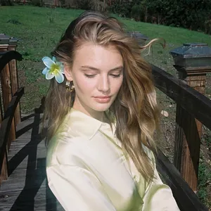 Elegant gold flower hair claw clip with blue gradient petals on a fashion model