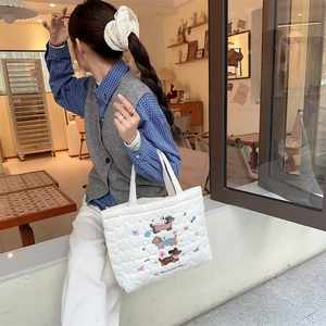 Close-up of quilted white tote bag with dachshund embroidery and Have a nice day text