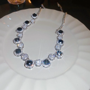Detailed view of luxury silver necklace featuring a deep blue square gem with small diamonds