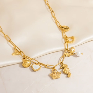 Detail of 18K gold-plated paperclip chain necklace with sea shell and crown pendants