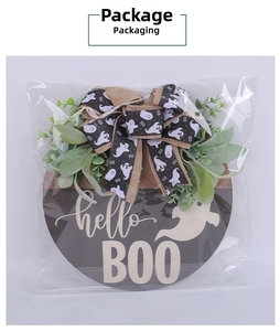 Detail of Halloween ghost door hanger with greenery and bow in clear packaging