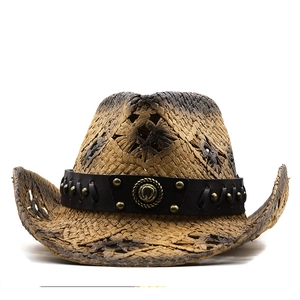 Detail of straw cowboy hat with black leather band and retro metal horseshoe badge