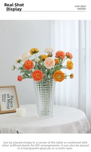 Detail of multi-colored ranunculus flowers in a geometric textured glass vase