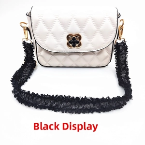Detail of white quilted bag with clover gold clasp and black tweed fringed strap