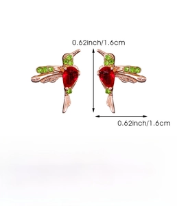 Detailed view of hummingbird stud earrings with green crystals and red drop stones