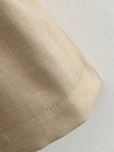Close-up of the beige linen-textured fabric with high-quality single-needle stitching finish
