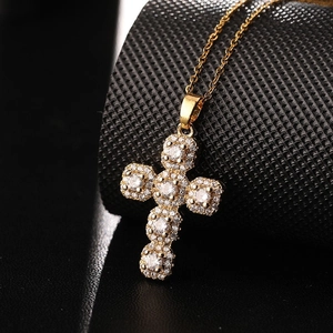 Classic gold cross pendant necklace with sparkling white zircons on black background