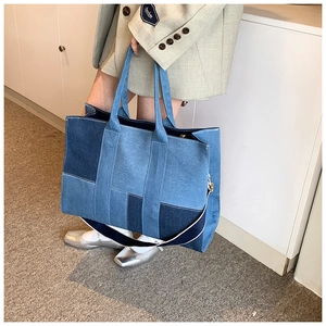 Close-up of patchwork denim tote bag showing blue fabric textures and shoulder strap