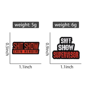 Macro shot of two satirical enamel pins featuring Shit Show Supervisor text design