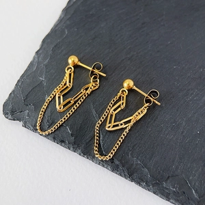 Detail of 18k gold plated double chain drop earrings on minimalist slate background