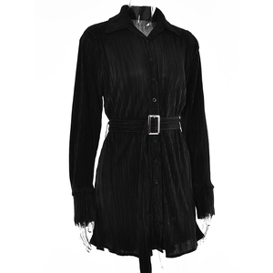 Detailed close-up of black pleated shirt dress texture with waist belt and metal buckle