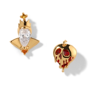 Detailed view of asymmetric earrings featuring a golden crown and red skull apple with zircons