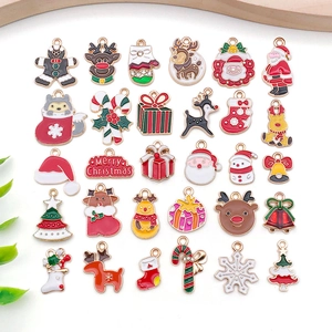 Macro shot of 24 assorted Christmas enamel charms including Santa, elk, and trees